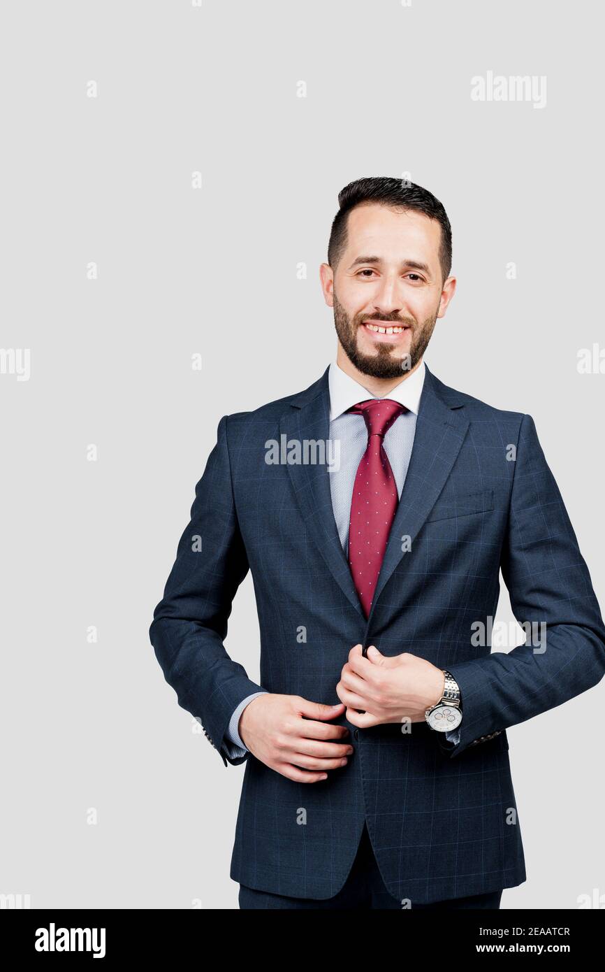 Bell'uomo d'affari arabo in tuta sorride su sfondo bianco in studio. Ritratto di affari dell'uomo riuscito Foto Stock