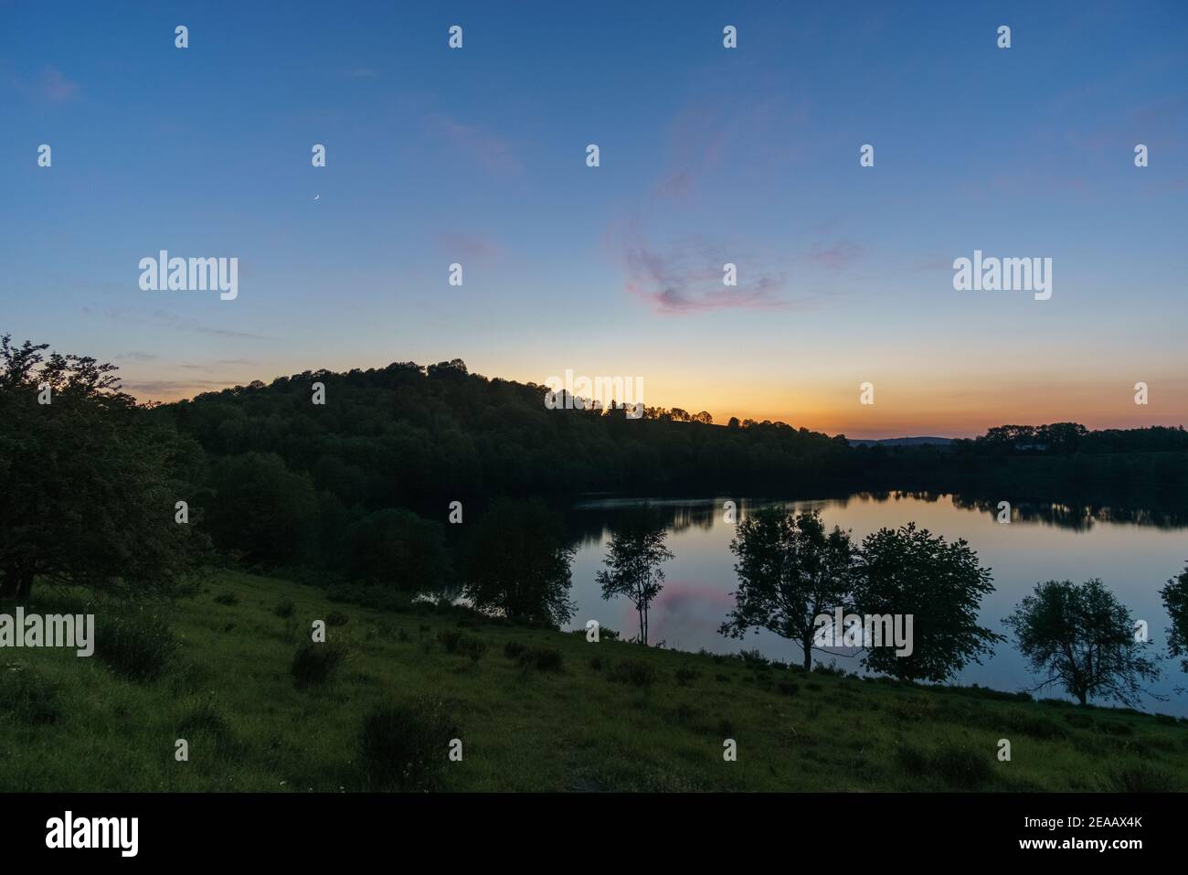 Luna di crescent sul lago al tramonto, Weinfelder Maar, Germania, Daun, Foto Stock