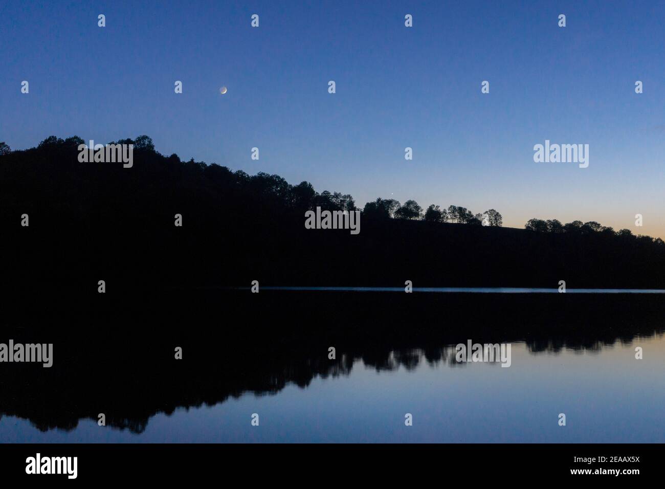 Luna di crescent e pianeta mercurio sul lago al tramonto, Weinfelder Maar, Germania, Daun, Foto Stock