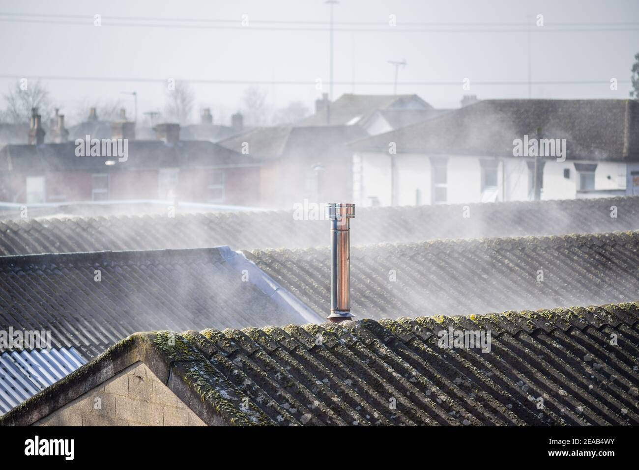 Tetti fumanti - evaporazione dai tetti bagnati in condizioni climatiche gelide, accelerata dalle superfici di riscaldamento del sole, Southampton, Inghilterra, Regno Unito Foto Stock