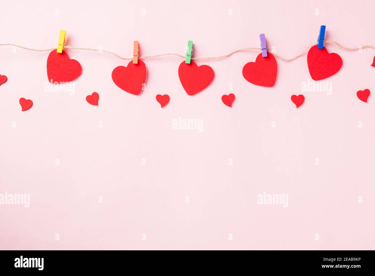 Buon San Valentino sfondo giorno. Cuore rosso decorazione valentine a forma di cuore appeso con graffette sulla corda per amore composizione biglietto di auguri isola Foto Stock