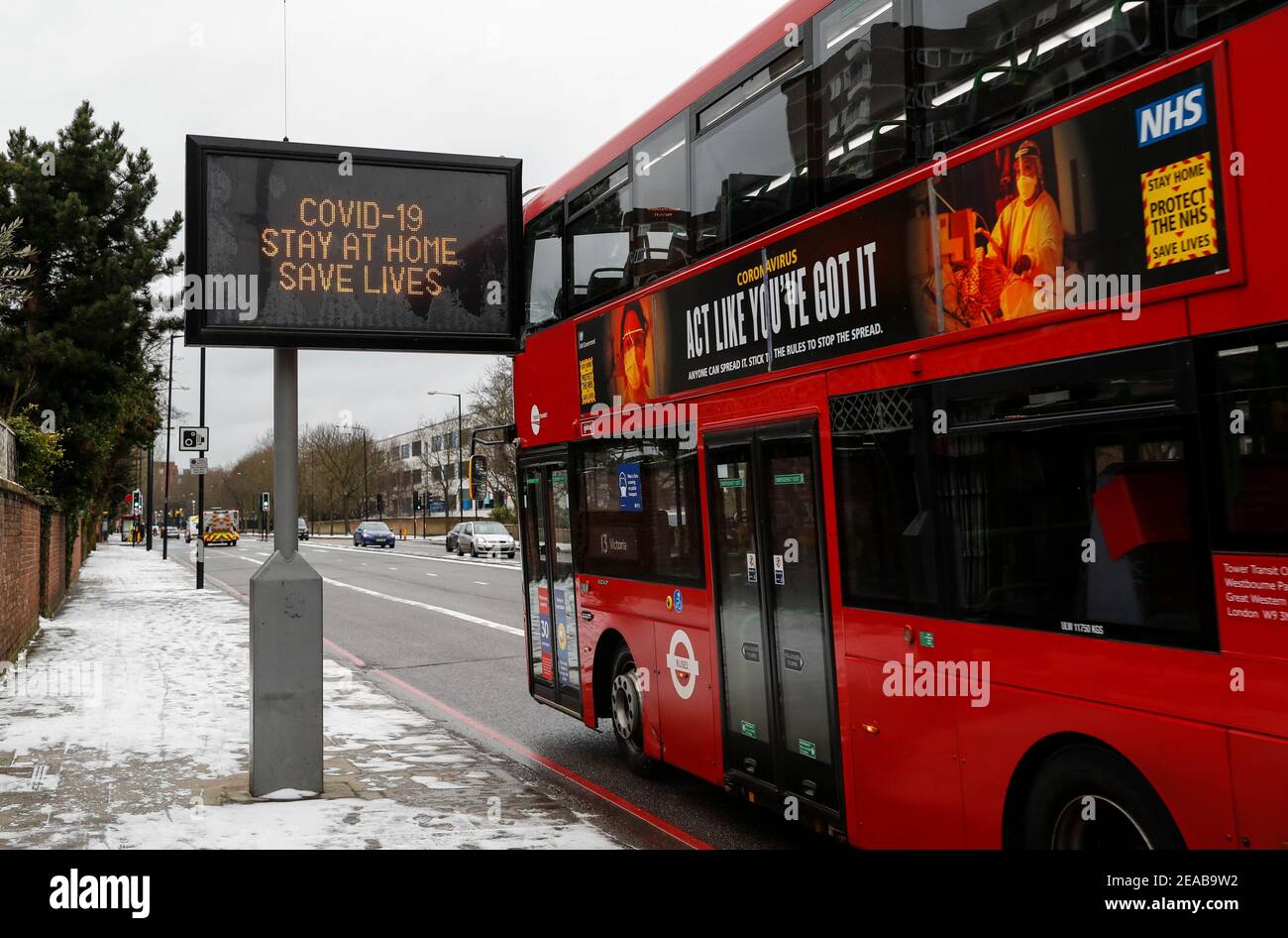 Londra, Gran Bretagna. 8 Feb 2021. Un autobus passa davanti a una scheda elettrica a Londra, in Gran Bretagna, l'8 febbraio 2021. Altre 14,104 persone in Gran Bretagna hanno dato risultati positivi per COVID-19, portando il numero totale di casi di coronavirus nel paese a 3,959,784, secondo i dati ufficiali rilasciati lunedì. Credit: Han Yan/Xinhua/Alamy Live News Foto Stock