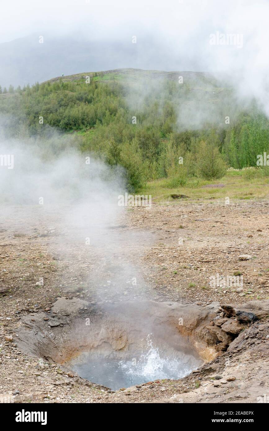 Strokkur, Strokkur Geyser che è solo riposo, parte del Golden Ring nella valle di acqua calda Haukadalur, Islanda del Sud Foto Stock