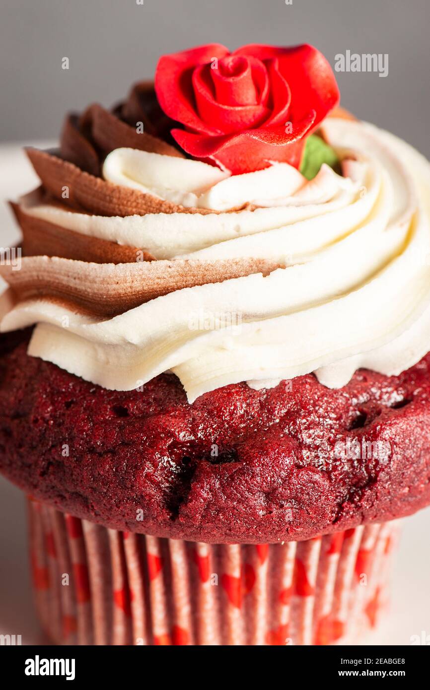 Cupcake di velluto rosso a tema San Valentino con cioccolato e vaniglia glassa di buttercream Foto Stock