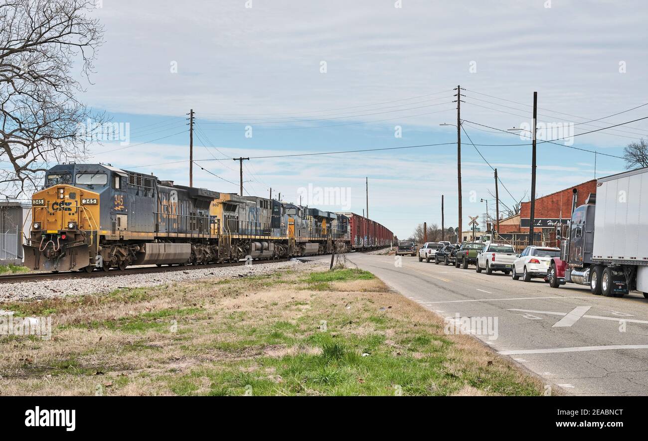 Il treno ferroviario CSX per il trasporto merci ha fermato il traffico ad un attraversamento del treno non custodito a Montgomery Alabama, USA. Foto Stock