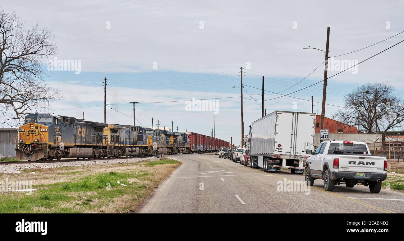 Il treno ferroviario CSX per il trasporto merci ha fermato il traffico ad un attraversamento del treno non custodito a Montgomery Alabama, USA. Foto Stock