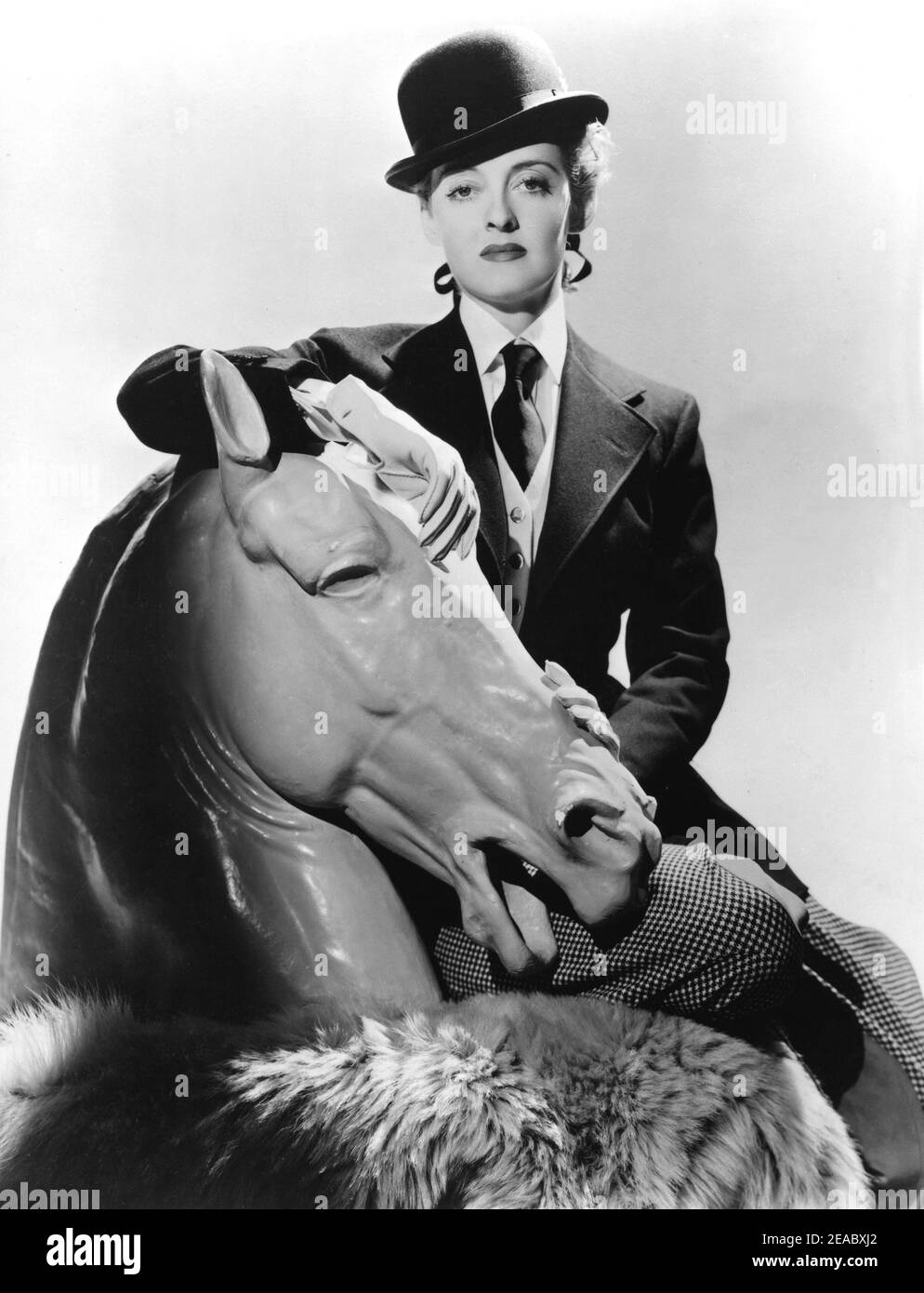 1939 , USA : l'attrice cinematografica BETTE DAVIS ( 1908 - 1989 ) in una publicità ancora per il film DARK VICTORY ( Tramonto ) Di Edmund Goulding - CINEMA - FILM - attrice - ritratto - ritratto - cavallerizza - amazzone - bombetta - cravatta - cravatta - colletto - colletto - cavallo - cavallo - scultura - scultura - pantaloni - pantaloni - cappello derby - cappello - pelliccia - pelliccia - ---- Archivio GBB Foto Stock