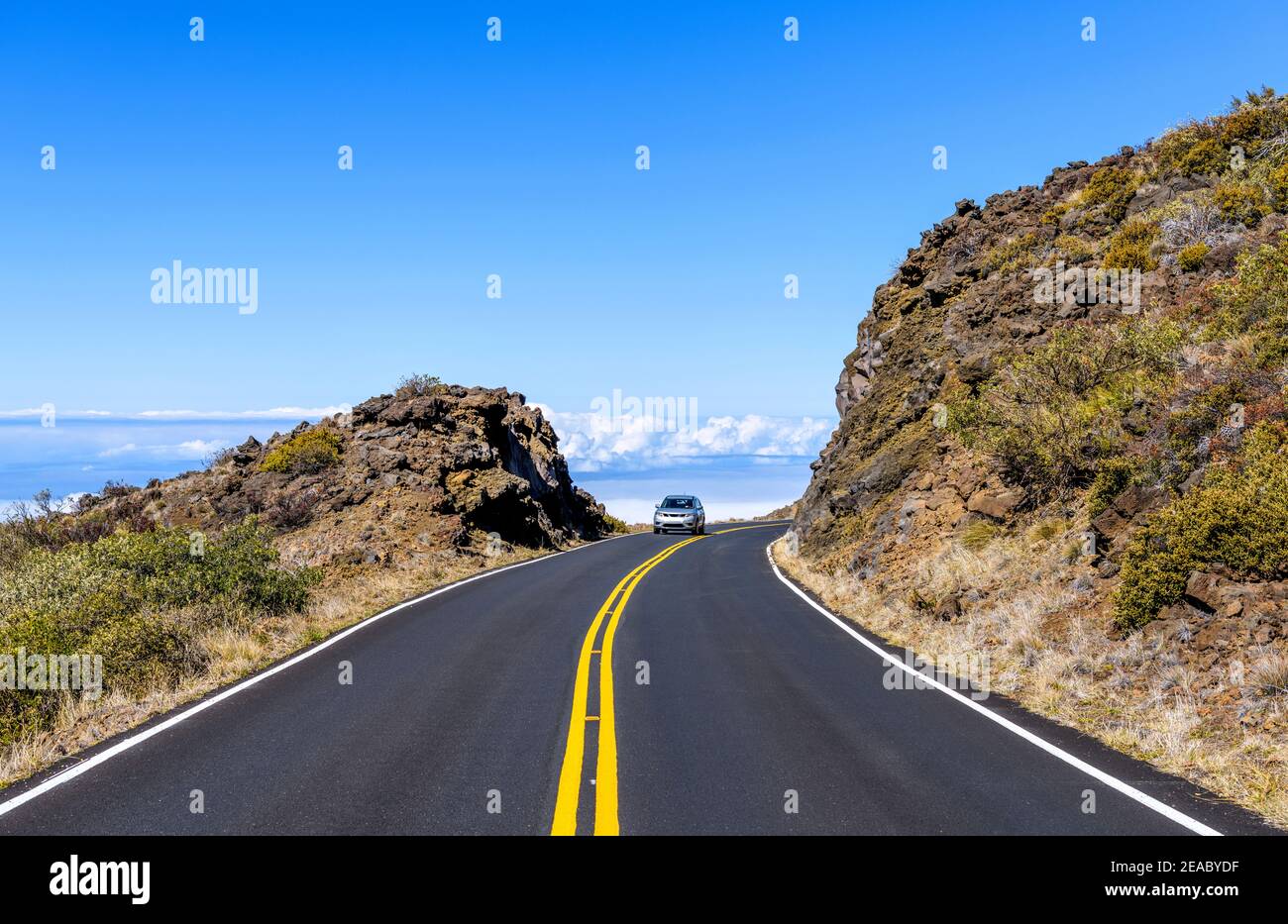 Winding Road - UN SUV di medie dimensioni che guida sulla tortuosa autostrada Haleakala nel Parco Nazionale di Haleakala in un luminoso pomeriggio di sole. Maui, Hawaii, Stati Uniti. Foto Stock