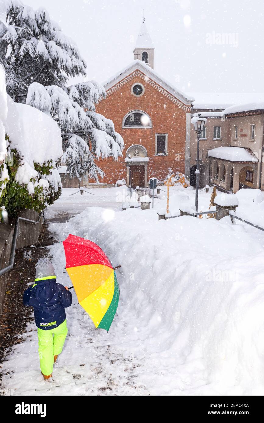 Camminando nella neve nel villaggio di Cles. Cles, Val di non, Trentino Alto Adige, Italia, Europa Foto Stock