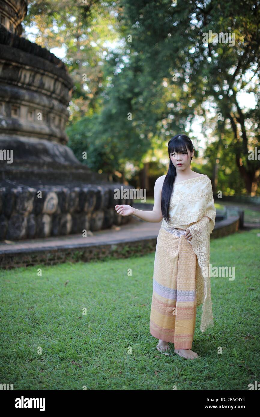 Ritratto di donna tailandese con abito tradizionale tailandese con tempio sfondo Foto Stock