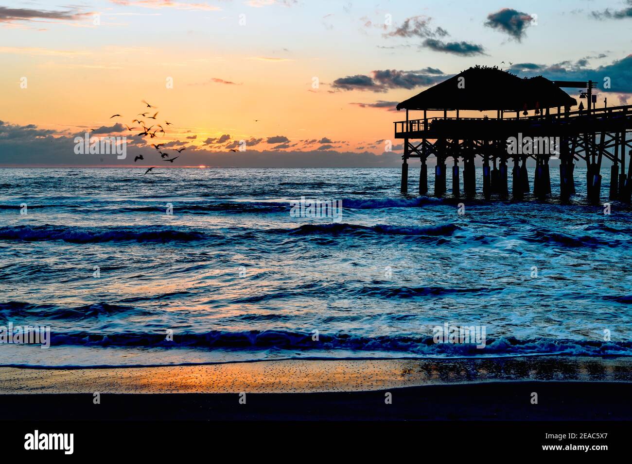 Tramonto sul molo di Cocoa Beach, vista sull'oceano con il sole che tramonta Foto Stock