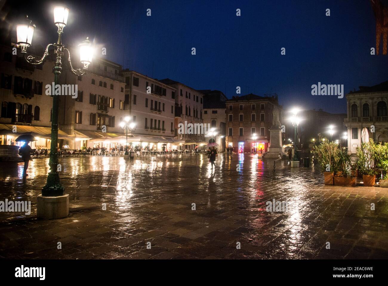 Piazza illuminata a Venezia quando piove Foto Stock