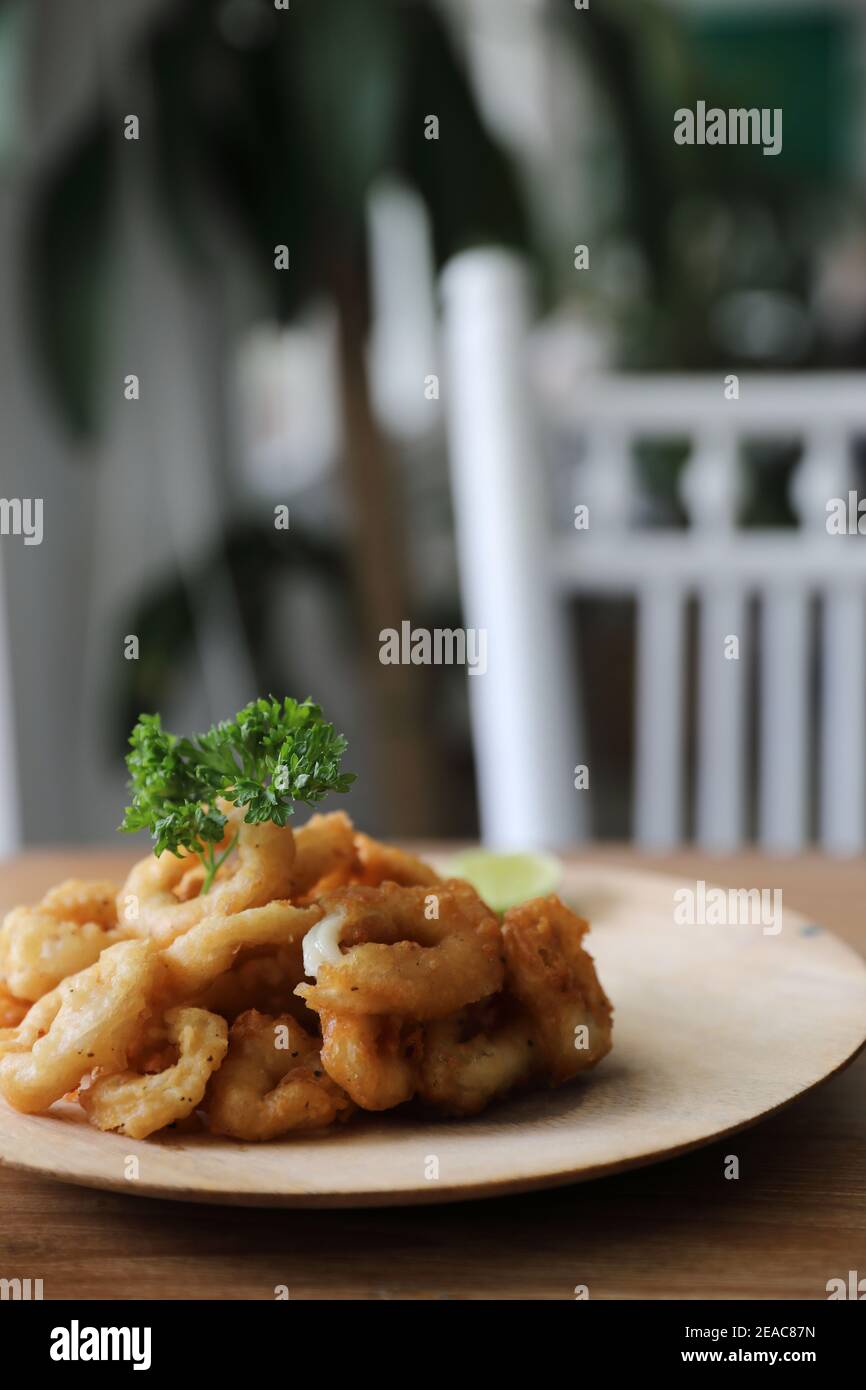 Caramari , Ang di calamari fritti croccanti con salsa tartaro su fondo di legno tradizionale cucina italiana Foto Stock