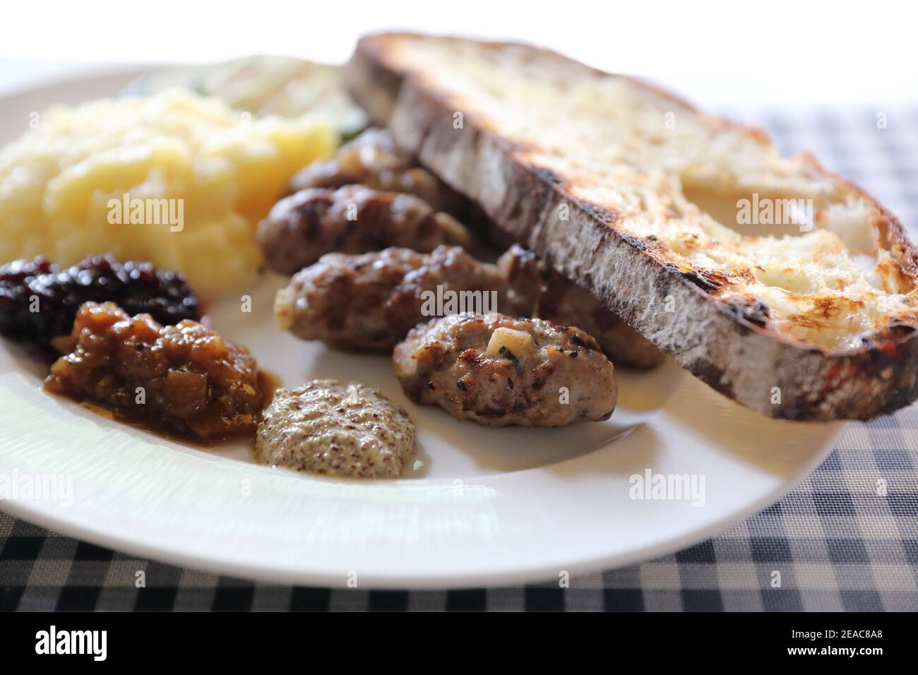 Salsiccia alla griglia con pane e patate e salsa di marmellata di frutta cucina Foto Stock