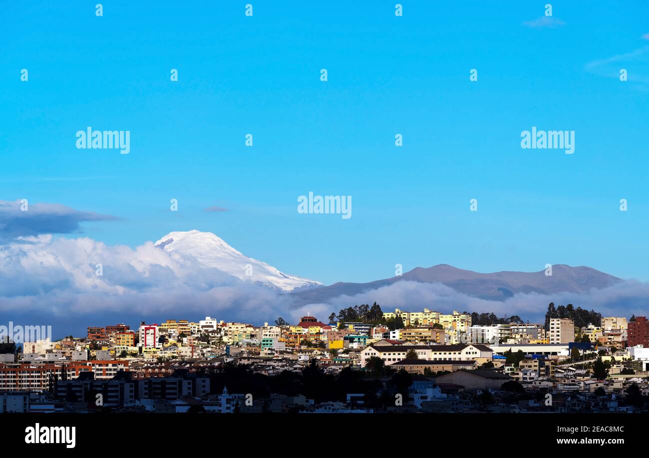 Skyline aereo di Quito al tramonto con il vulcano Cayambe e copia spazio, Ecuador. Foto Stock