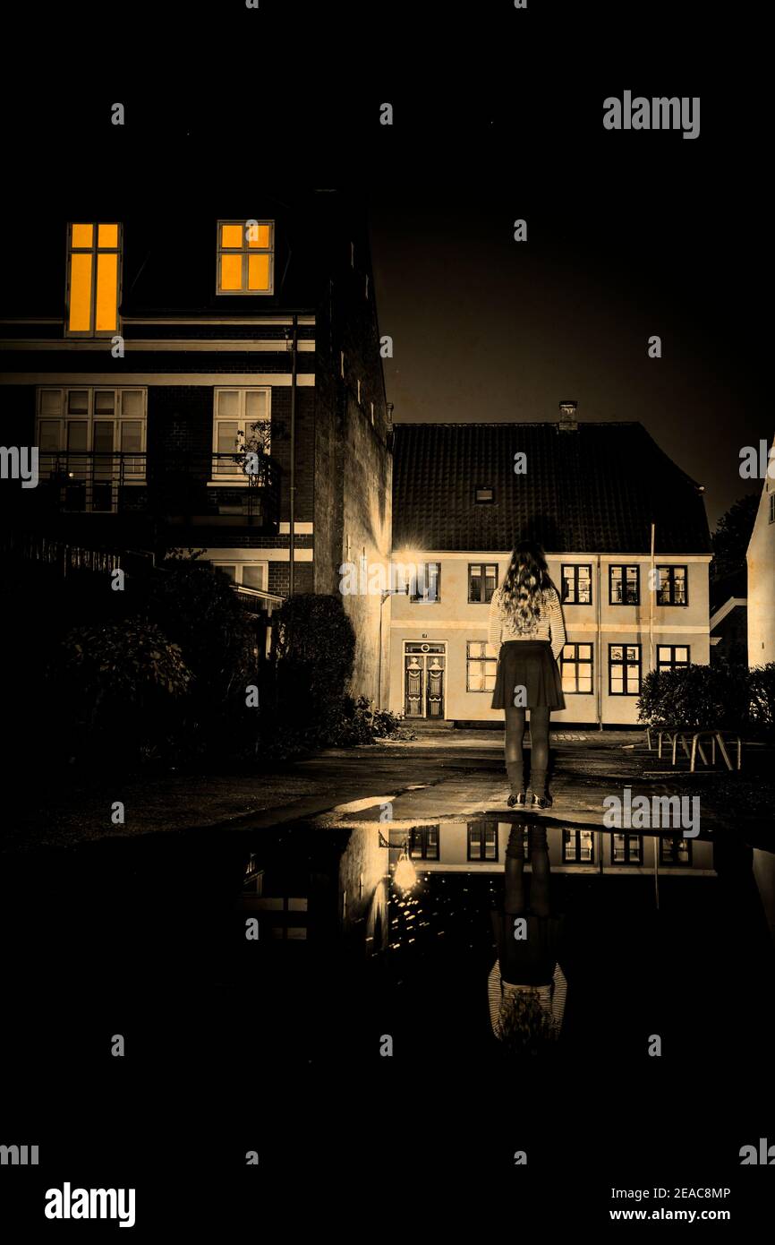 Donna con una gonna corta in una piccola città danese di notte Foto Stock