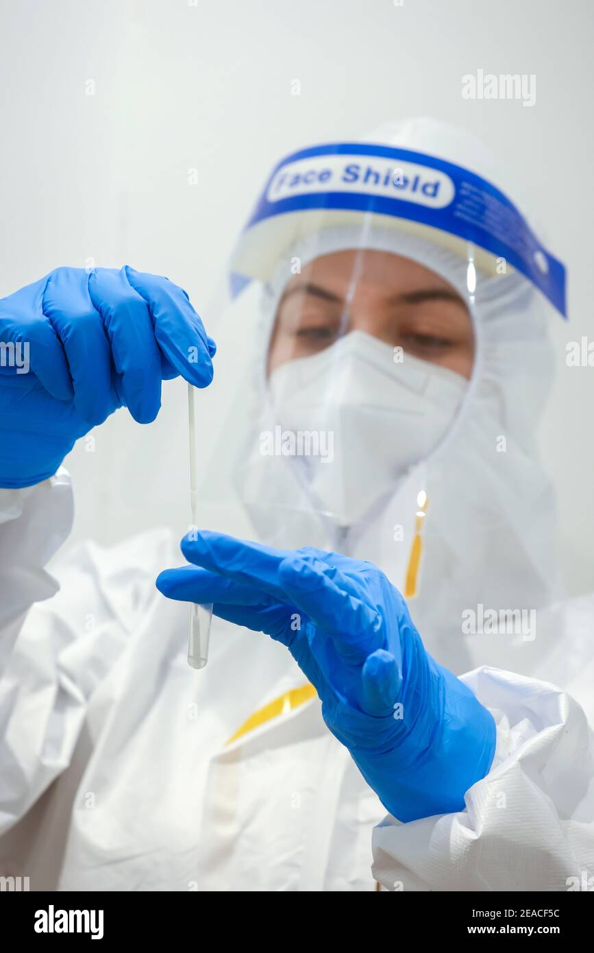 Colonia, Nord Reno-Westfalia, Germania - Test rapido Covid presso il centro di test Medicare, il tampone su tampone di cotone viene posto in una soluzione di supporto. Foto Stock