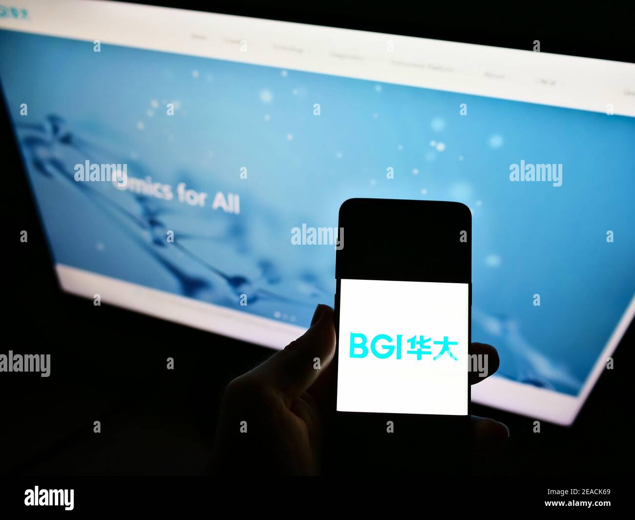 Persona titolare smartphone con logo della società cinese di sequenziamento genoma BGI Group su schermo con il sito web aziendale. Mettere a fuoco il display del telefono. Foto Stock