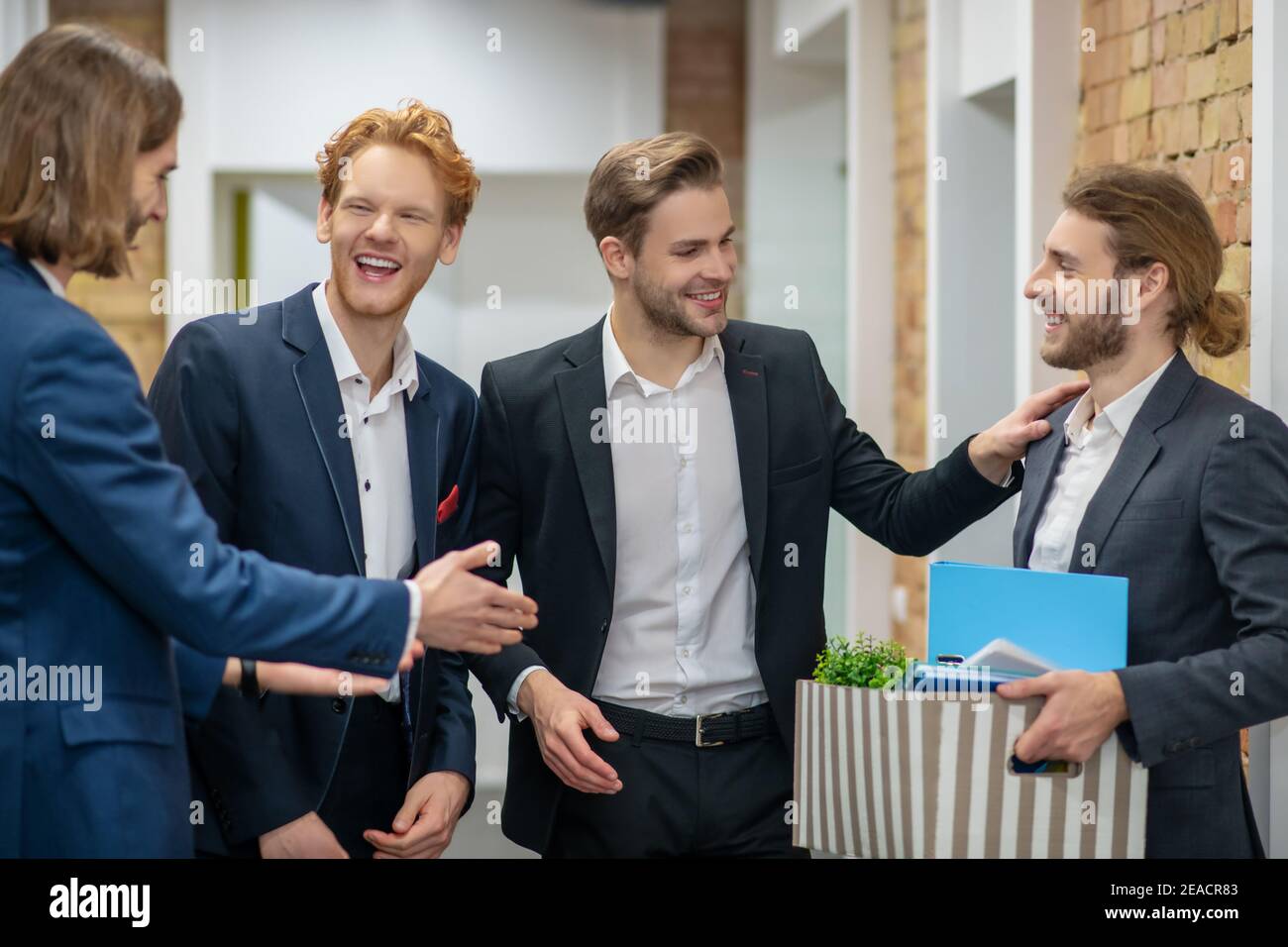 Ridendo giovani che chiacchierano in ufficio Foto Stock