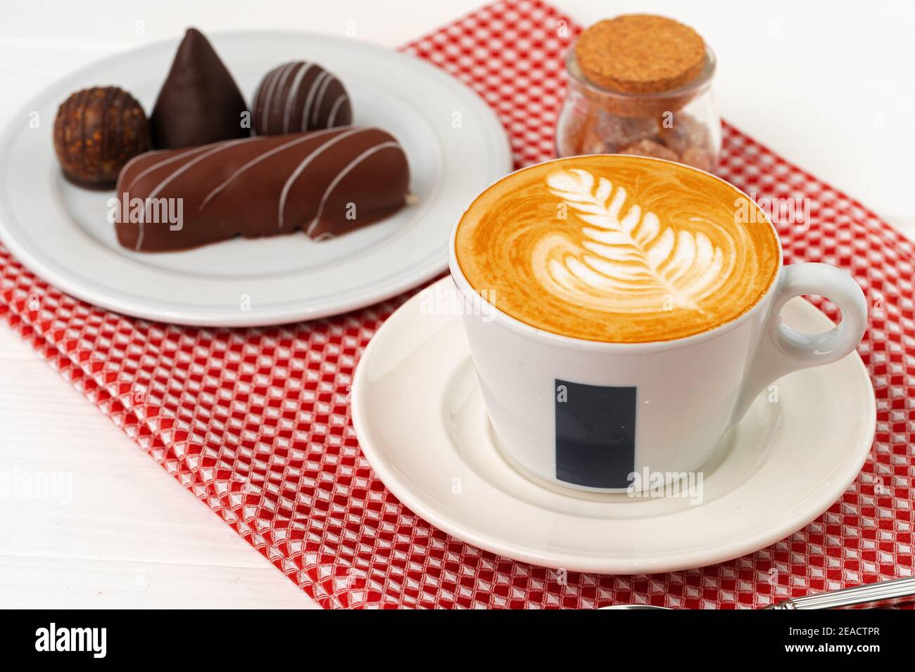 Tazza di caffè e piattino con dolci al cioccolato su legno tabella Foto Stock