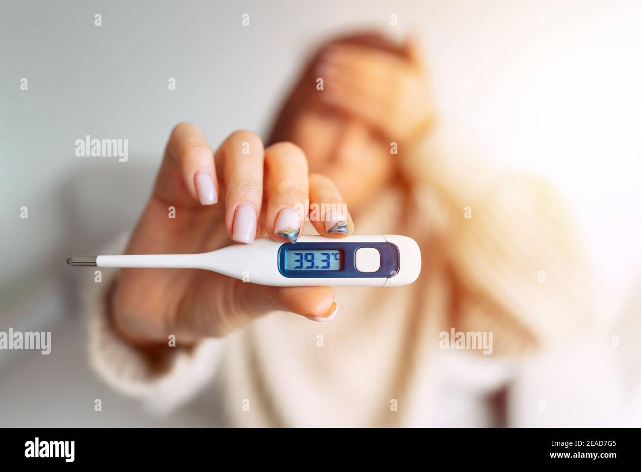 Donna malata con febbre alta che mostra termometro con alto temperatura  corporea 39.3 Foto stock - Alamy