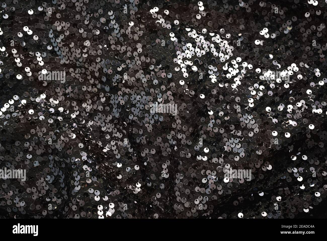 Paillette lucenti su tessuto nero Foto Stock