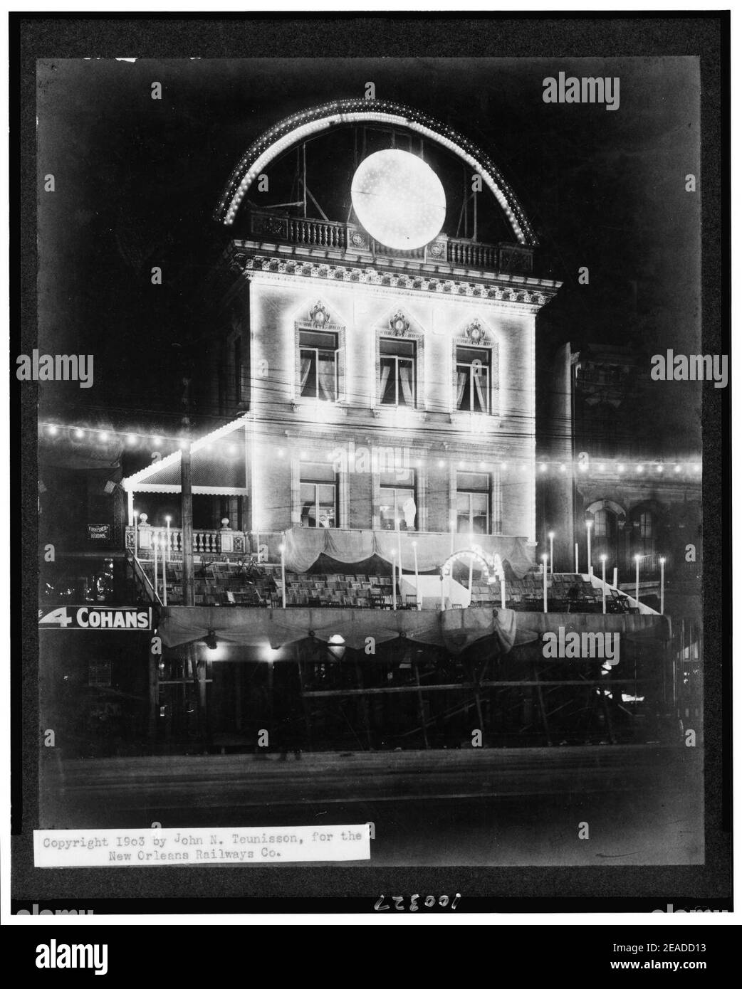 Scena notturna che mostra hotel illuminato per il Mardi Gras, con posti a sedere sulla piattaforma di fronte, New Orleans, Louisiana Foto Stock