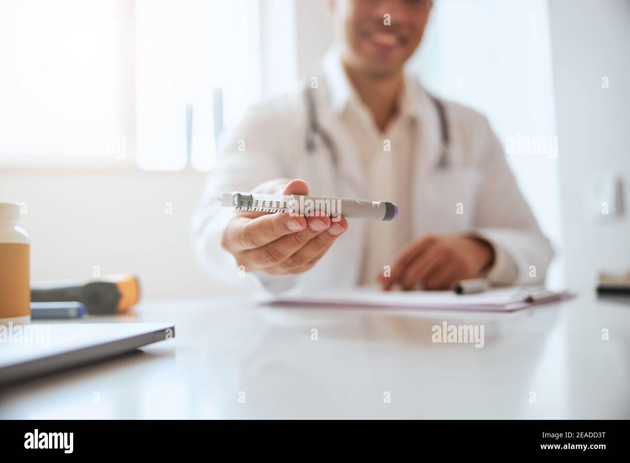 Immagine del terapeuta che mostra la siringa nelle braccia nella stanza all'interno Foto Stock