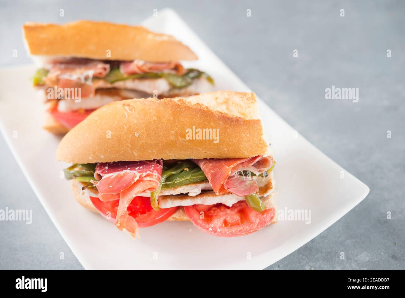 Sandwich Serranito tipico dell'Andalusia con prosciutto, pepe e lombo di maiale alla griglia Foto Stock