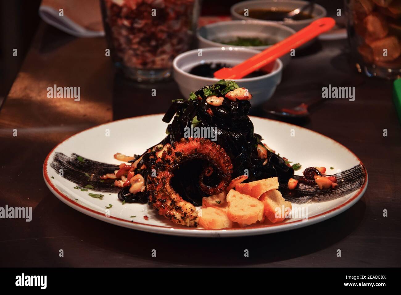 Tagliatelle sull'inchiostro Cuttlefish, con un unico Caesar nero e polpo caramellato Foto Stock
