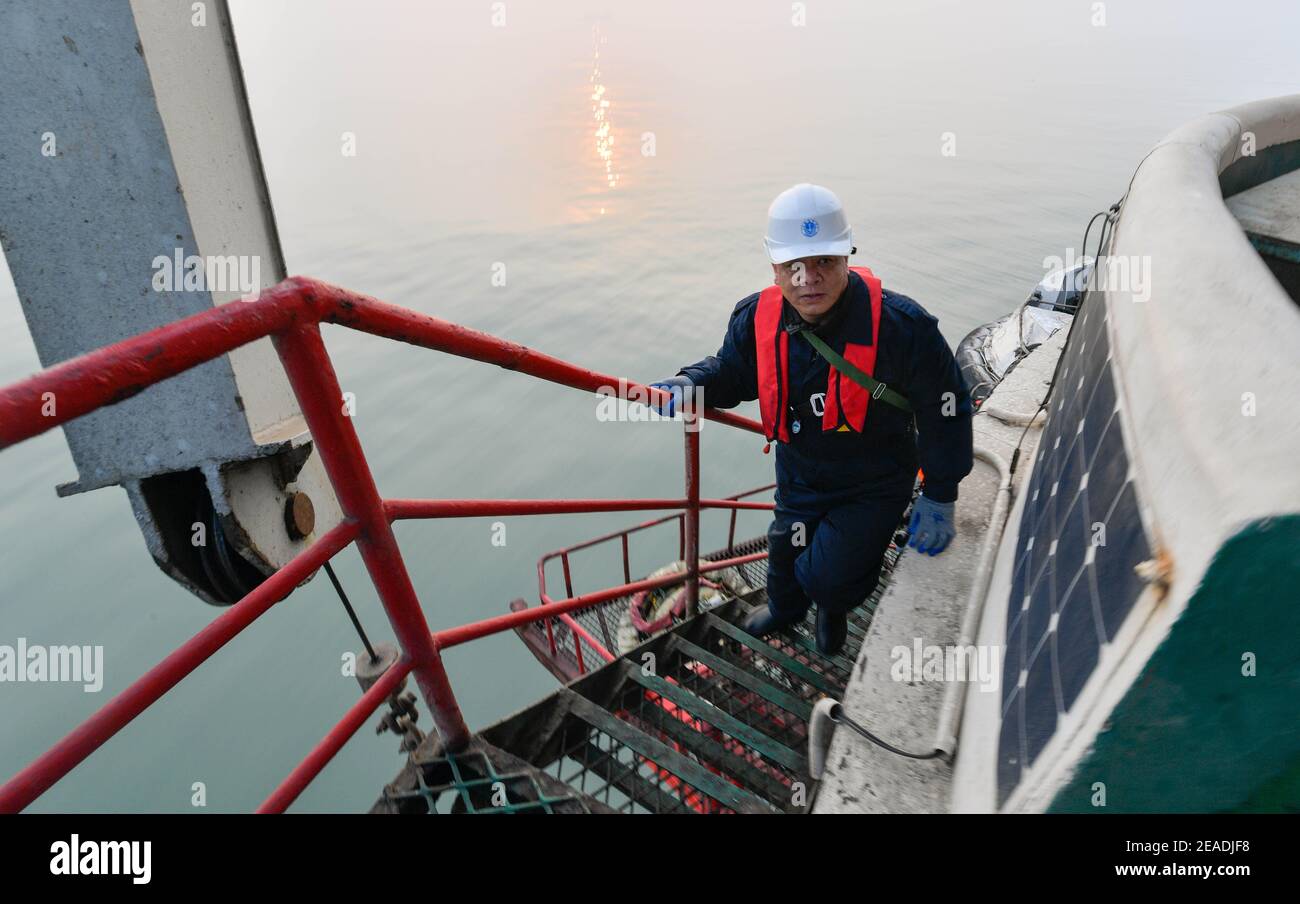 (210209) -- TIANJIN, 9 febbraio 2021 (Xinhua) -- li Hongqi sale le scale al faro di Dagu, che si trova a 12.9 miglia nautiche ad est del porto di Tianjin del comune di Tianjin della Cina settentrionale, il 20 gennaio 2021. Il faro di Dagu alto 38.3 metri, con una portata di 17 miglia nautiche, è stato messo in funzione dal 1° maggio 1978. Li Hongqi, 47 anni, è un custode del faro di Dagu. I custodi qui lavorano in una rotazione di un mese, mantenendo le luci del faro per garantire la navigazione sicura delle navi. Le necessità giornaliere sono servite una volta al mese e i custodi si rivolgono ai dispositivi di illuminazione e di riscaldamento solo quando n Foto Stock