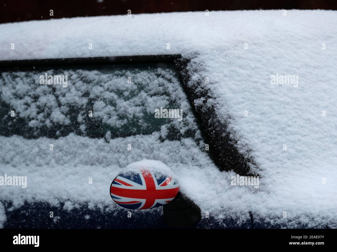 Coalville, Leicestershire, Regno Unito. 9 febbraio 2021. Meteo nel Regno Unito. Uno specchio alare Mini CooperÕs stampato con una bandiera Union si stacca dalla neve. Credit Darren Staples/Alamy Live News. Foto Stock