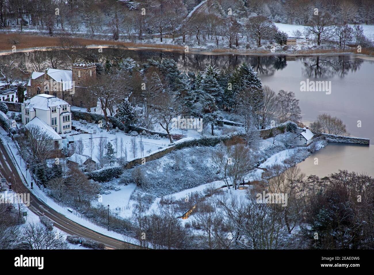 Holyrood Park Edimburgo, Scozia, Regno Unito. 9 febbraio 2021. Il Parco Holyrood innevato ha incoraggiato le persone a giocare e ad allenarsi tra le docce. Nella foto: Duddingston Loch e Kirk bella come una foto nella neve. Foto Stock