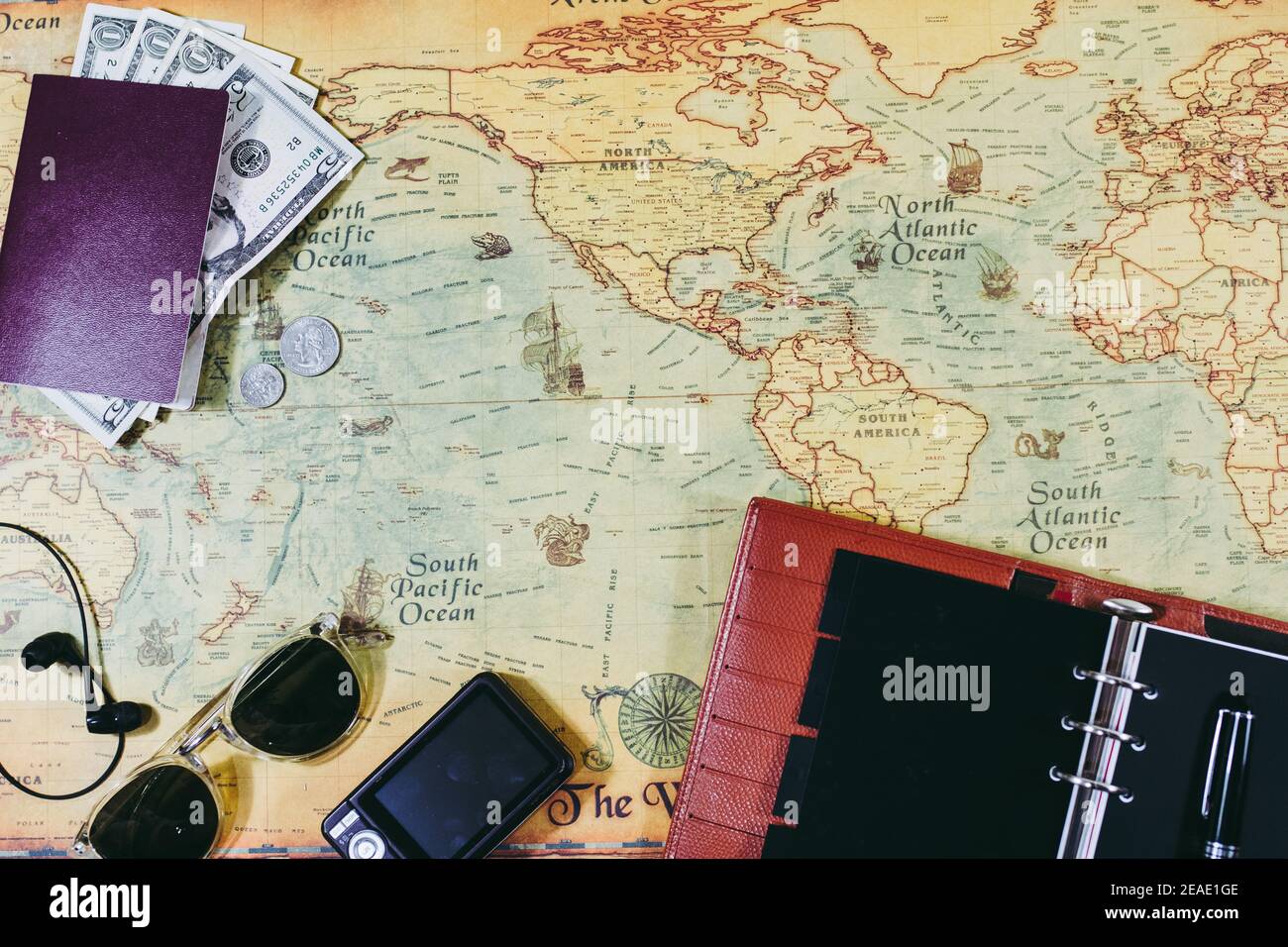 accessori da viaggio. Vista dall'alto di oggetti da viaggio, passaporto, valuta del paese straniero, cuffie musicali, occhiali da sole, fotocamera fotografica e programma da prendere n Foto Stock