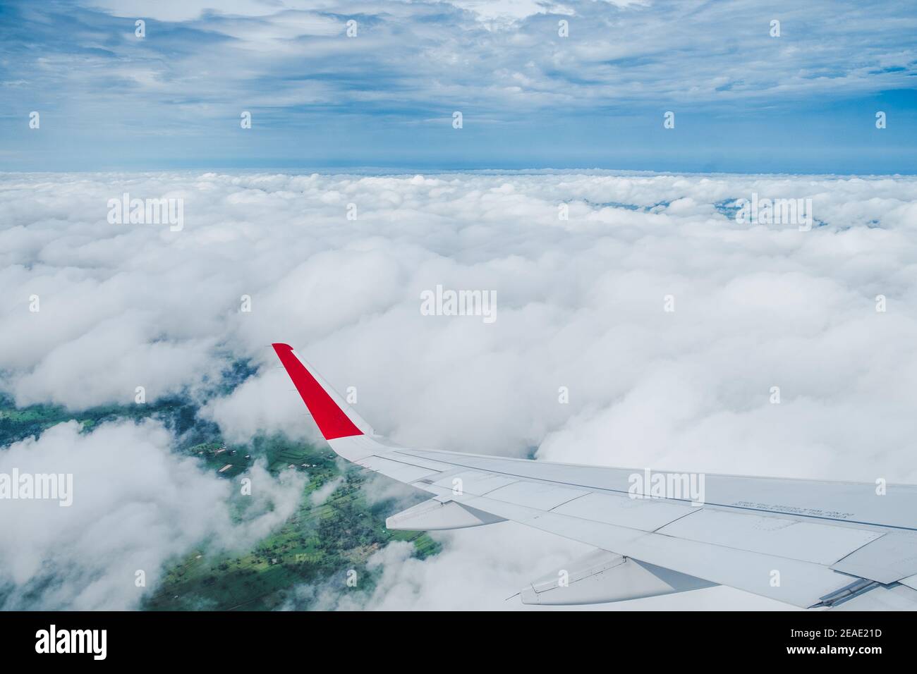 Vista dalla finestra dell'aereo, Ala di un aereo che vola sopra le nuvole con cielo blu. Foto Stock