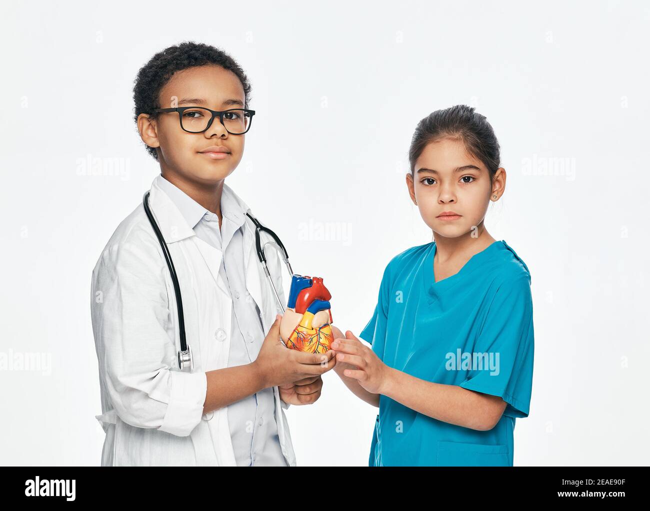 Due bambini carini che indossano un uniforme medica sono in posa e. guardando la fotocamera Foto Stock