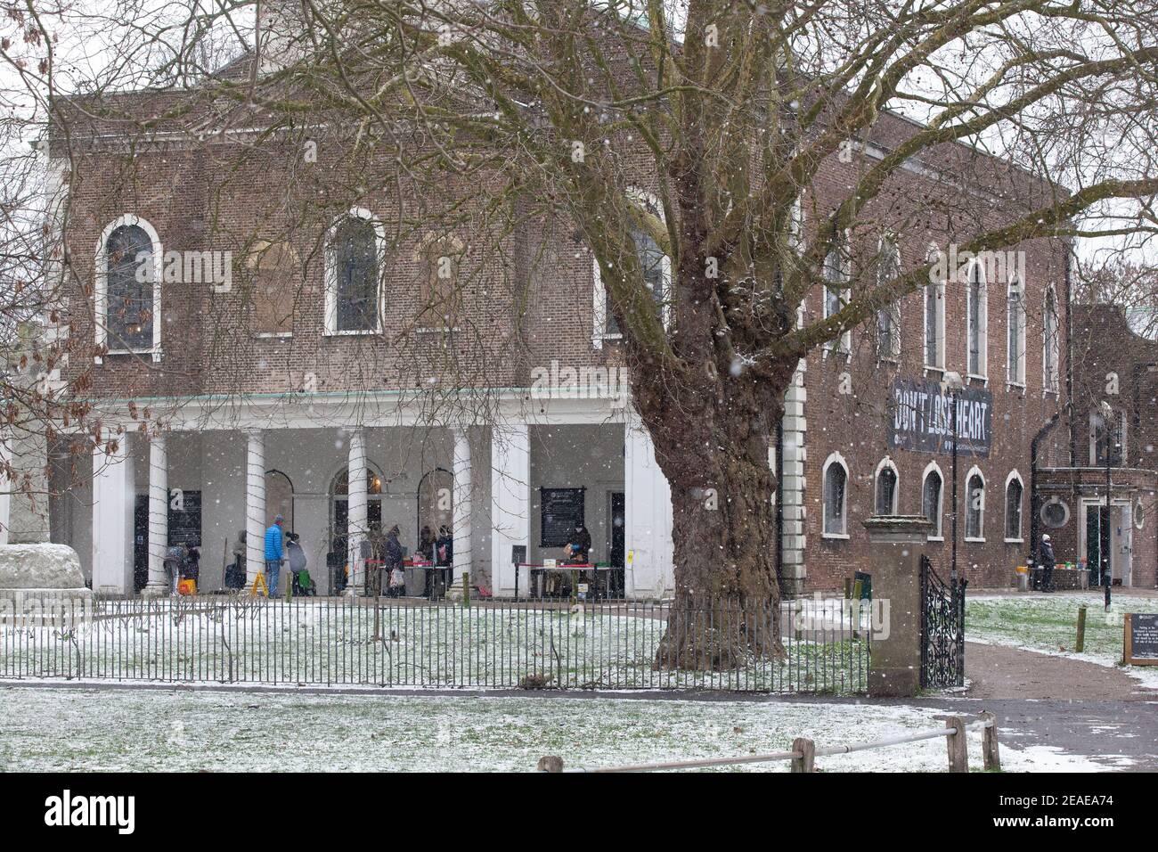 Londra, Regno Unito. 9 Feb 2021. Presso la chiesa della Santa Trinità a Clapham Common una banca di cibo gestisce un servizio di raccolta all'aperto e bevande calde sotto un cartello che dice "non perdere il cuore". Dopo tre giorni di neve a Londra inizia a stabilirsi e i venti sono caduti mentre Storm Darcy è passato. Credit: Anna Watson/Alamy Live News Foto Stock