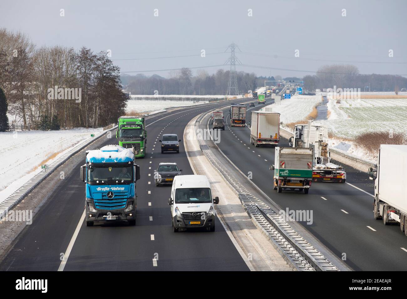Camion e auto che passano all'autostrada A67 durante l'inverno con Neve nei Paesi Bassi Foto Stock