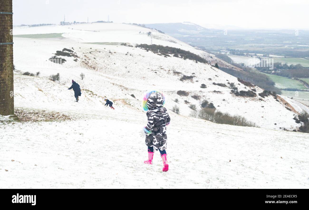 Brighton UK 9 febbraio 2021 - le famiglie godono la neve a Devils Dyke sulla strada di South Downs appena a nord di Brighton oggi come alcune parti della Gran Bretagna sperimentare il giorno più freddo dell'inverno finora: Credit Simon Dack / Alamy Live News Foto Stock