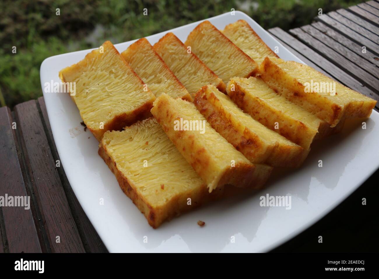 Bika Ambon, torta indonesiana a fette quadrate in piatto bianco. Torta gialla di Medan, Indonesia. Foto Stock