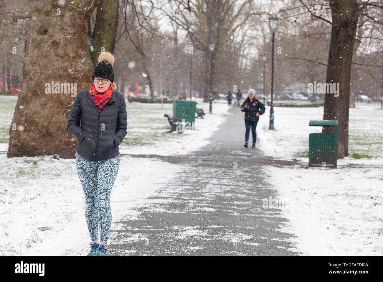 Londra, Regno Unito. 9 febbraio 2021: Dopo tre giorni di neve a Londra inizia a stabilirsi e i venti sono caduti mentre Storm Darcy è passato. Su Clapham Common alcune persone prendono esercizio, a piedi, o ritorno dai negozi. Credit: Anna Watson/Alamy Live News Foto Stock
