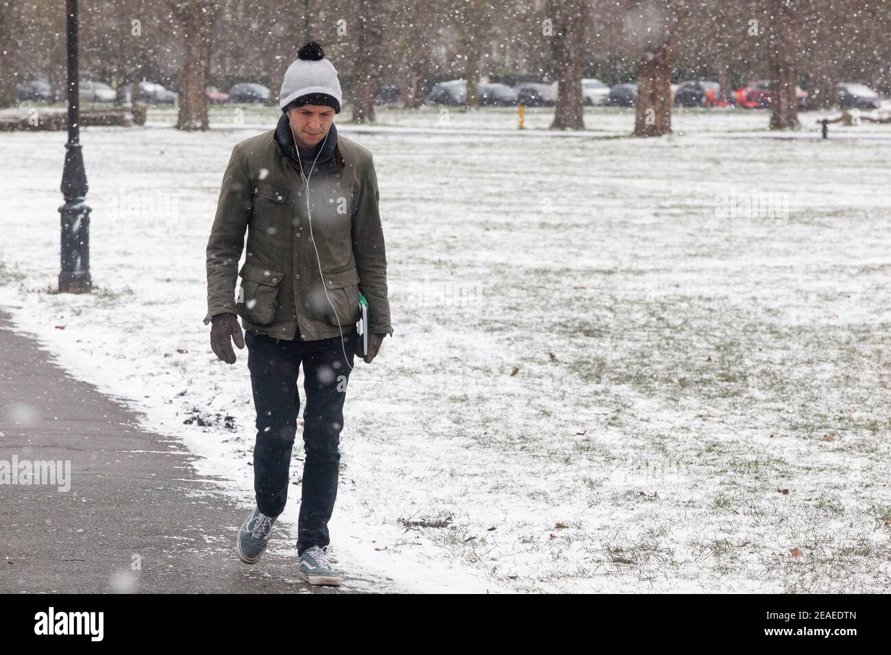 Londra, Regno Unito. 9 febbraio 2021: Dopo tre giorni di neve a Londra inizia a stabilirsi e i venti sono caduti mentre Storm Darcy è passato. Su Clapham Common alcune persone prendono esercizio, a piedi, o ritorno dai negozi. Credit: Anna Watson/Alamy Live News Foto Stock