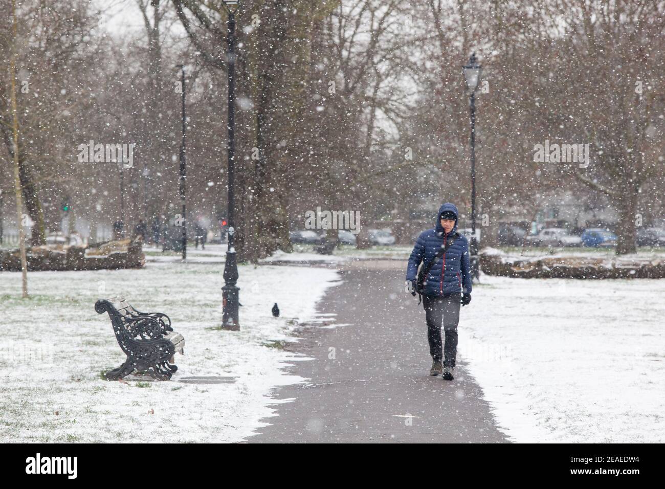 Londra, Regno Unito. 9 febbraio 2021: Dopo tre giorni di neve a Londra inizia a stabilirsi e i venti sono caduti mentre Storm Darcy è passato. Su Clapham Common alcune persone prendono esercizio, a piedi, o ritorno dai negozi. Credit: Anna Watson/Alamy Live News Foto Stock