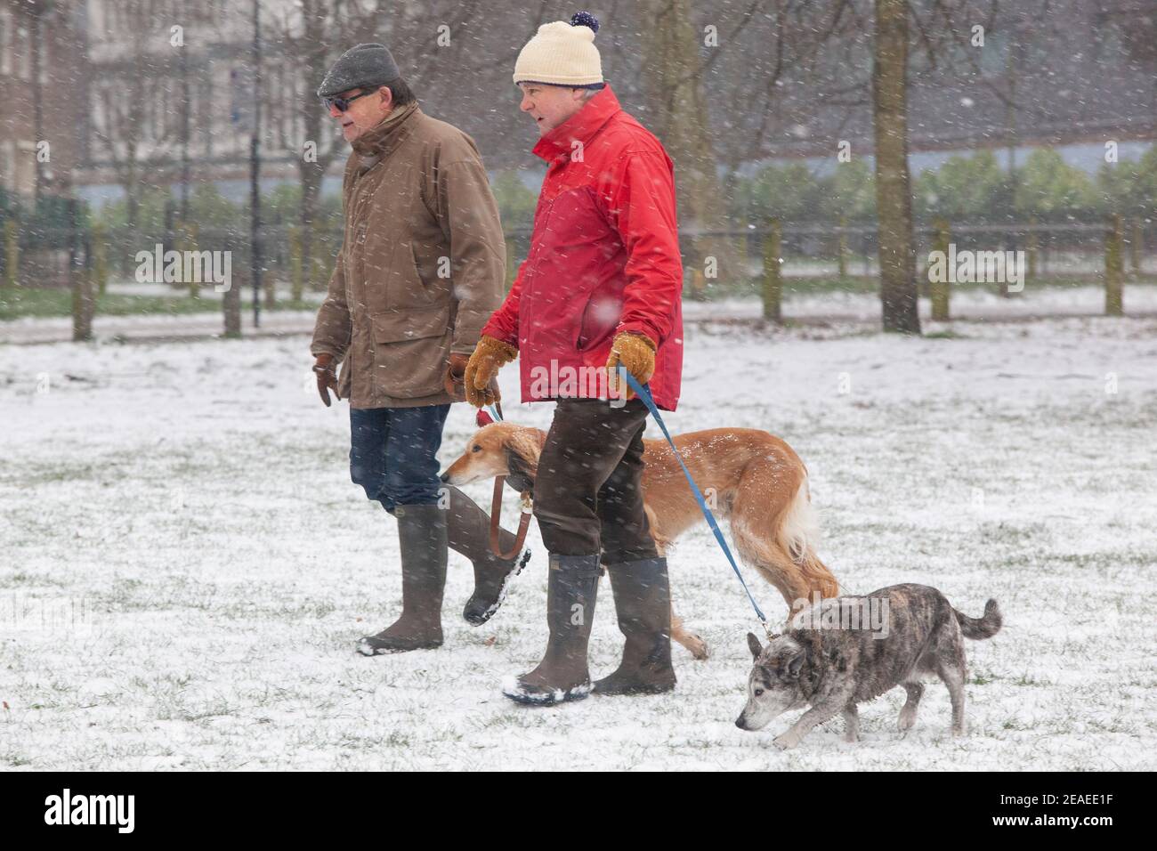 Londra, Regno Unito. 9 febbraio 2021: Dopo tre giorni di neve a Londra inizia a stabilirsi e i venti sono caduti mentre Storm Darcy è passato. Su Clapham comune alcune persone prendono l'esercizio e due uomini camminano i loro cani. Credit: Anna Watson/Alamy Live News Foto Stock