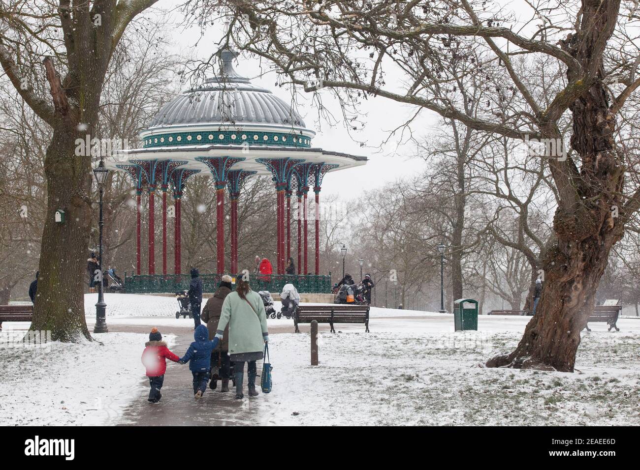 Londra, Regno Unito. 9 febbraio 2021: Dopo tre giorni di neve a Londra inizia a stabilirsi e i venti sono caduti mentre Storm Darcy è passato. Su Clapham Common alcune persone prendono l'esercizio vicino al supporto band con i loro bambini o cani. Anna Watson/Alamy Live News Foto Stock