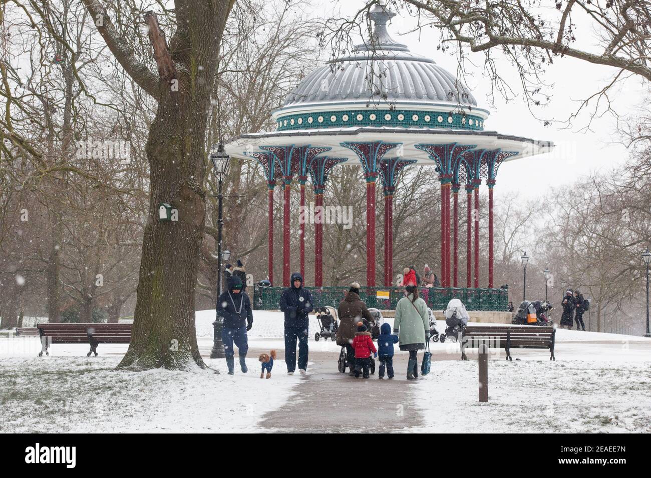 Londra, Regno Unito. 9 febbraio 2021: Dopo tre giorni di neve a Londra inizia a stabilirsi e i venti sono caduti mentre Storm Darcy è passato. Su Clapham Common alcune persone prendono l'esercizio vicino al supporto band con i loro bambini o cani. Anna Watson/Alamy Live News Foto Stock
