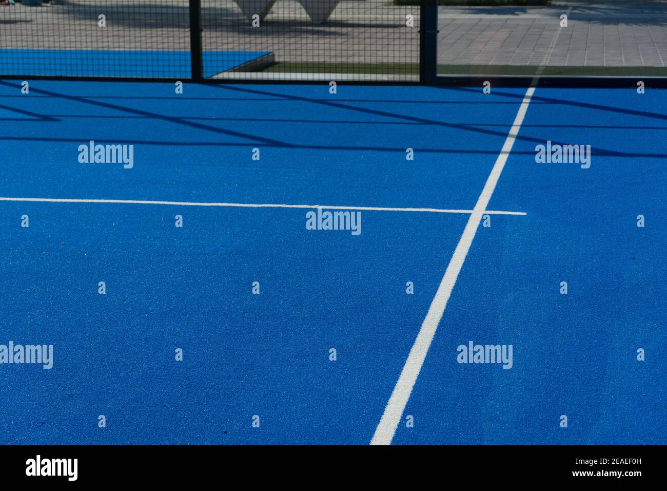 Campo da tennis, paddle ball o da sottoballe blu luminoso vicino alla linea di servizio base all'aperto. Foto Stock