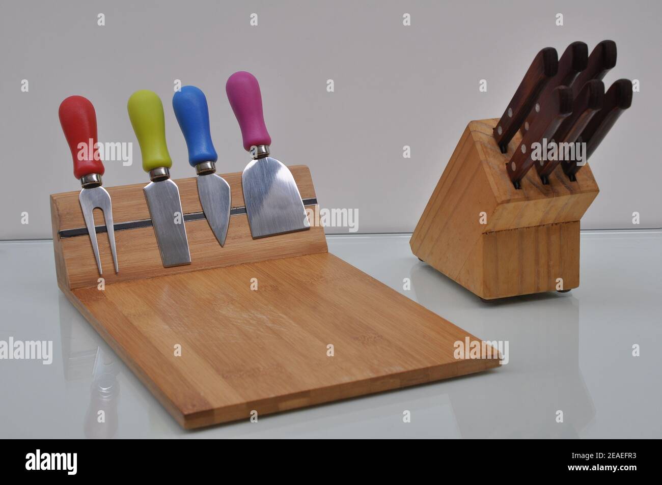 Accessori in legno da utilizzare in cucina con coltelli, taglierine, trituratori su sfondo bianco Foto Stock