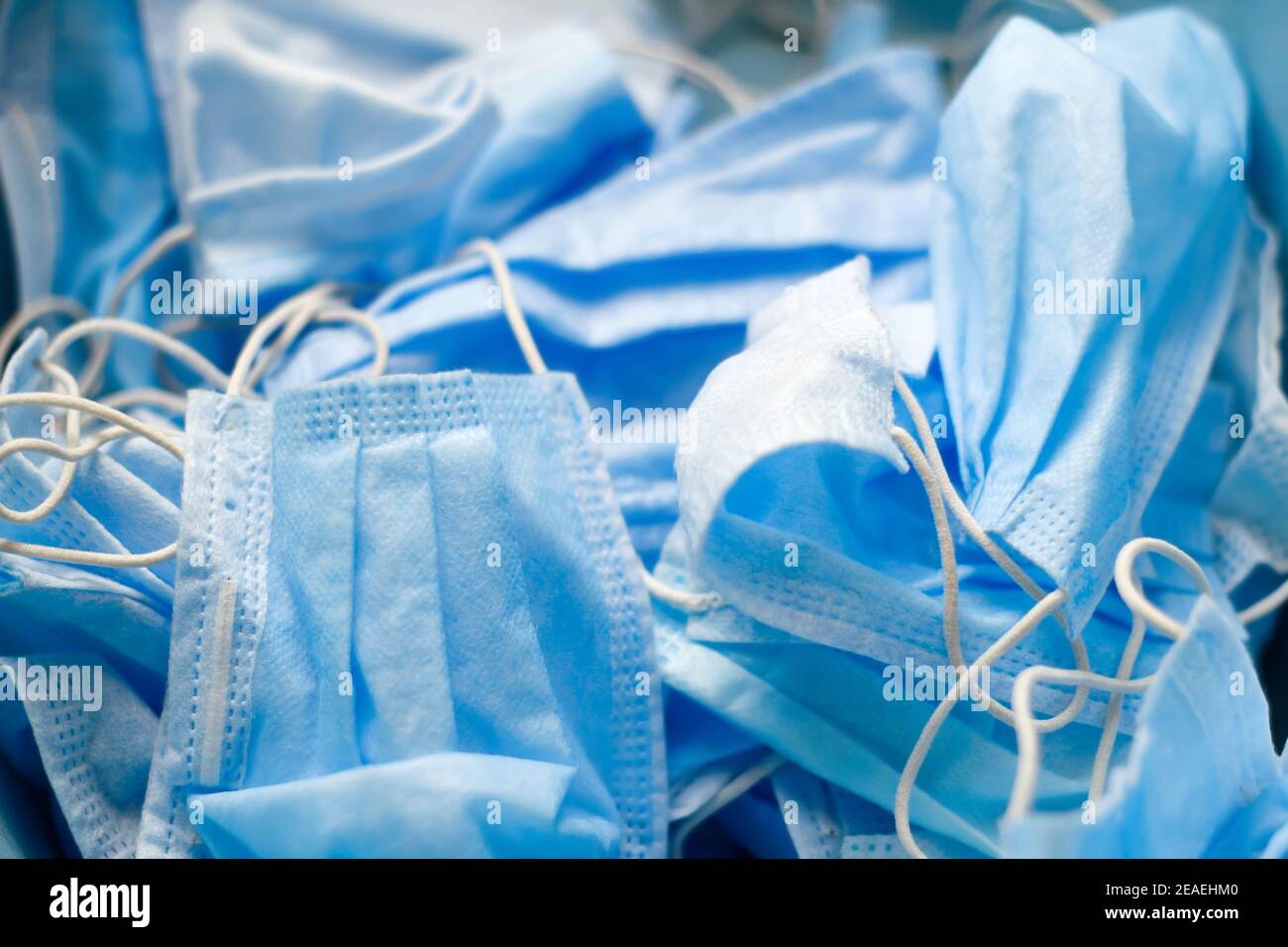 Primo piano un sacco di maschere blu sullo sfondo. Sfondo medico blu. La produzione di maschere contro il coronavirus covid 19. Sicurezza e. Foto Stock