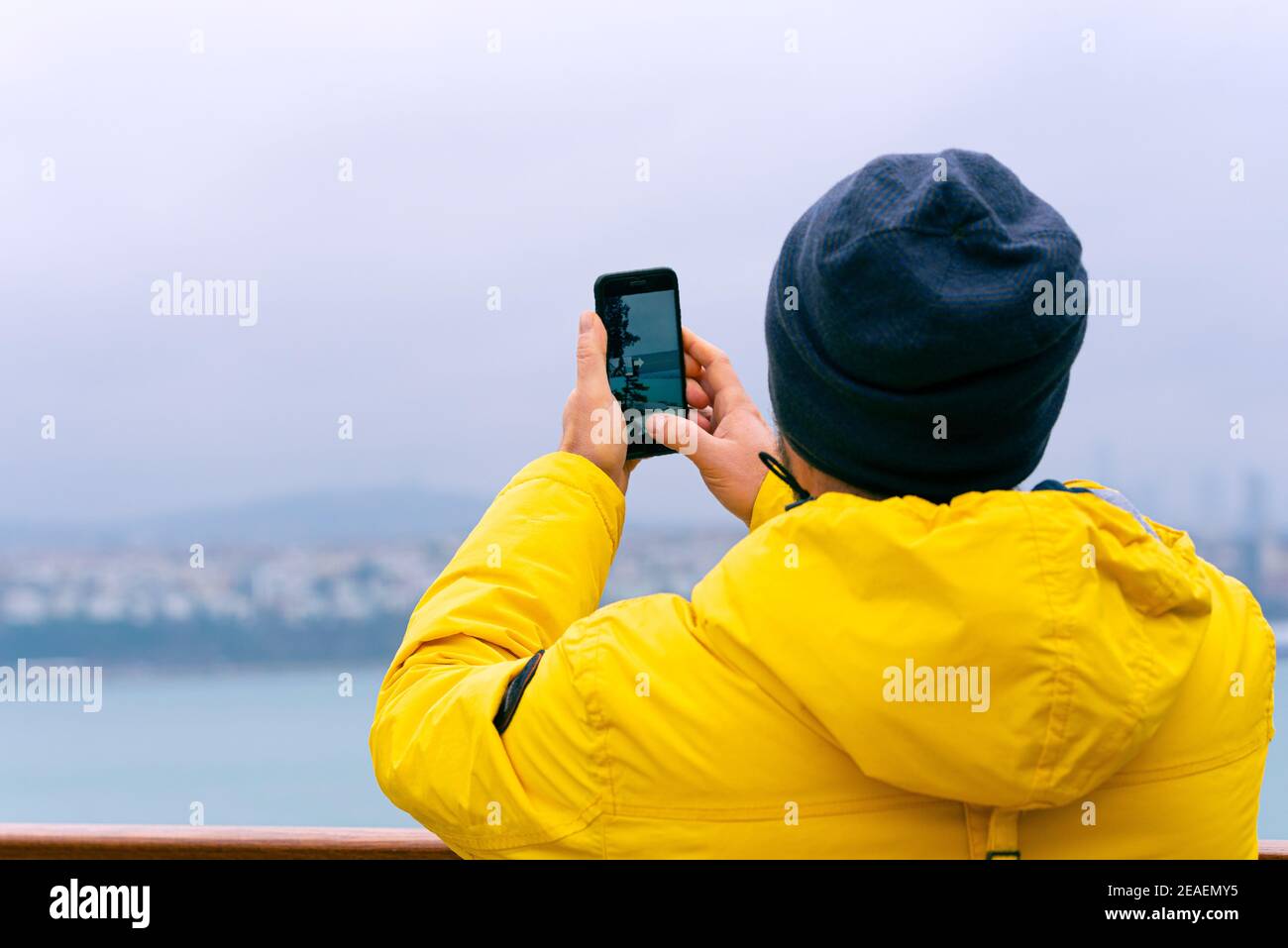 Un uomo turista che scatta foto per telefono alla vista Punto prima del Bosforo a istanbul durante la giornata invernale Foto Stock